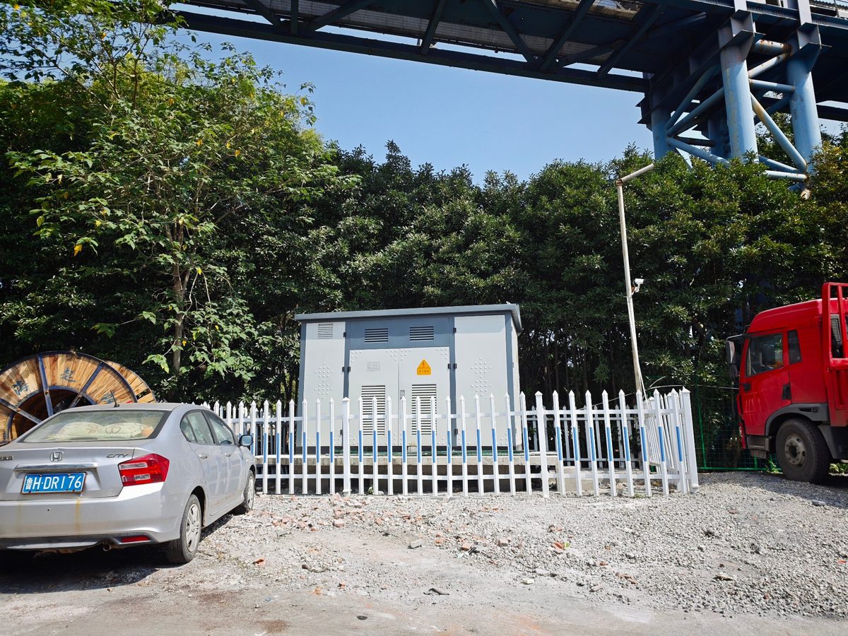祥荣再生资源场区充电站实拍：预装式箱式变电站与场区成品车辆、运输通道
