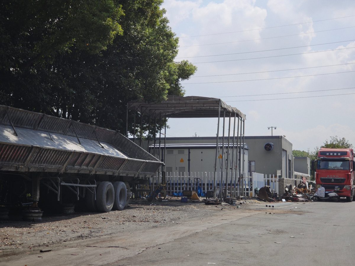 祥荣再生资源场区实拍：半挂自卸车、料棚与场区车辆进出通道