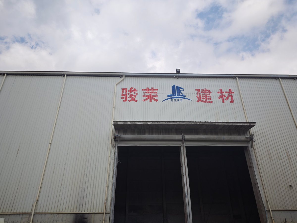 祥荣再生资源长条厂房外墙、卷帘门装卸口与屋面，场内运输道路贯通