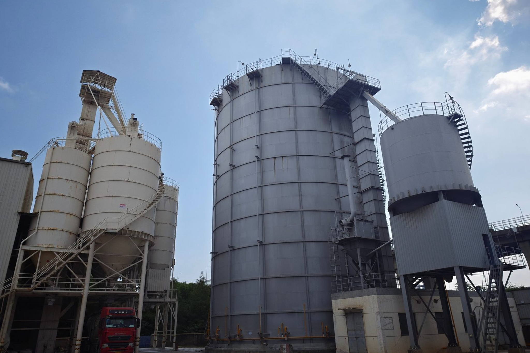 宁波镇海祥荣再生资源厂区实景：钢板筒仓群与物料输送廊，粉状再生建材原料分级储存设施